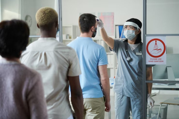 imgi 41 young female clinician uniform protective workwear measuring body temperature people standing row front he 2