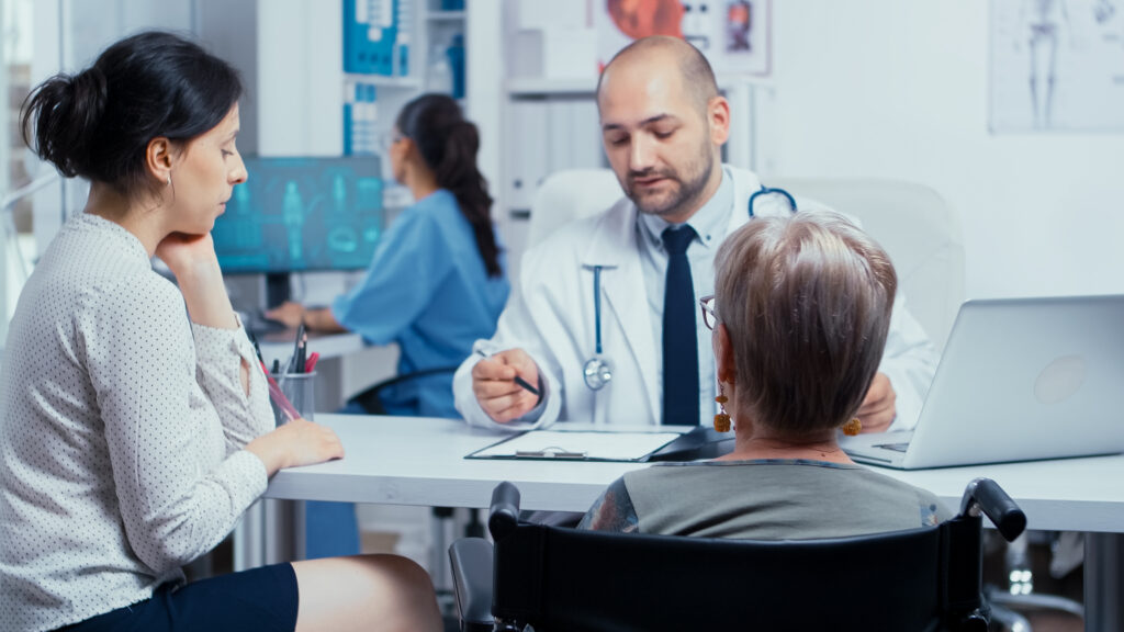 woman wheelchair with her daughter annual doctor appointment selective focus dsabled disability handicapped old person treatment modern private hospital clinic medicine health care